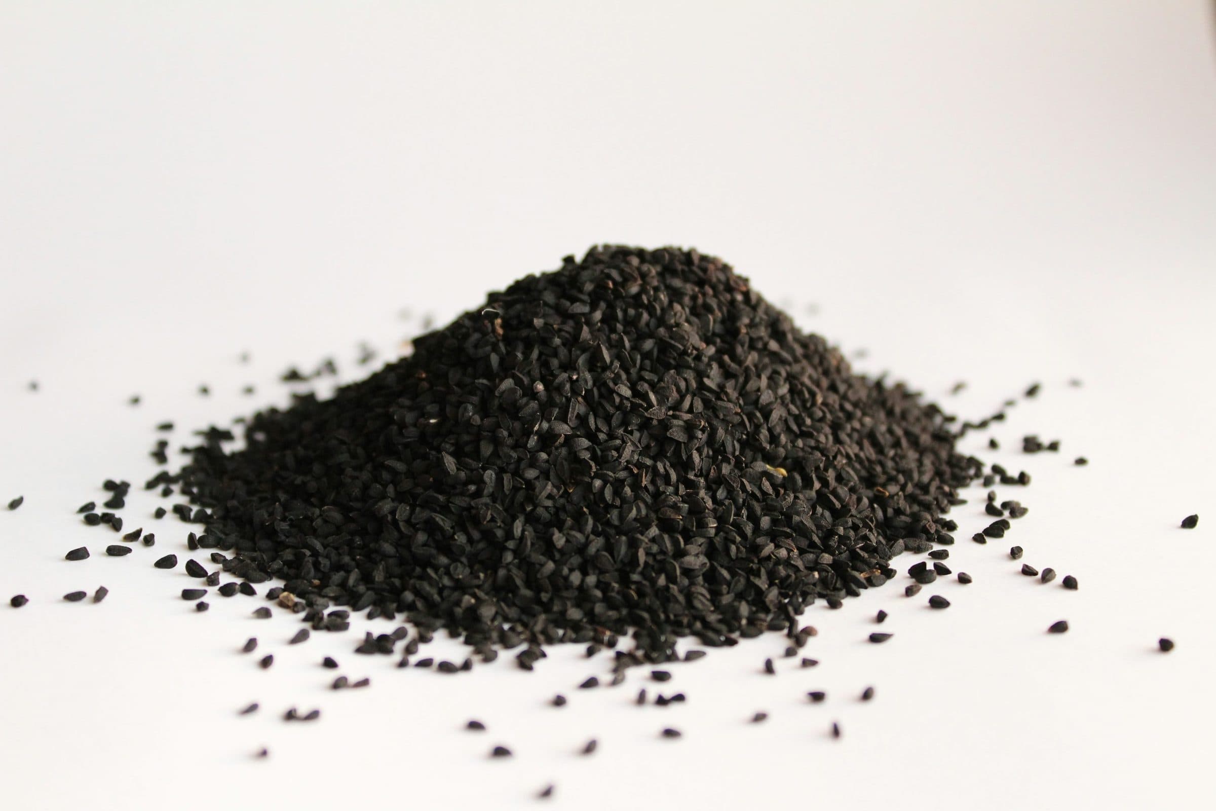 Black seed, honey and dates on a dark surface